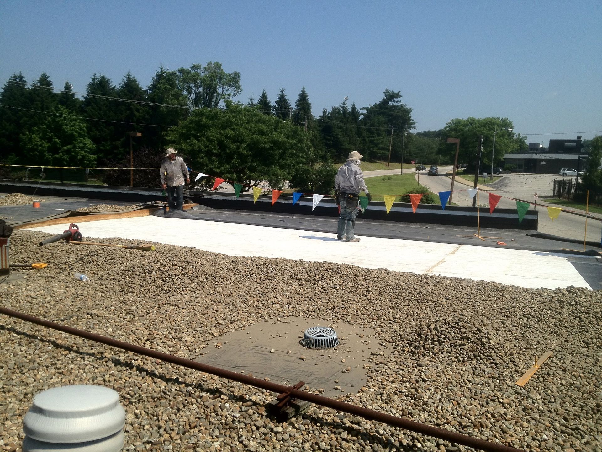 Two men are working on the roof of a building