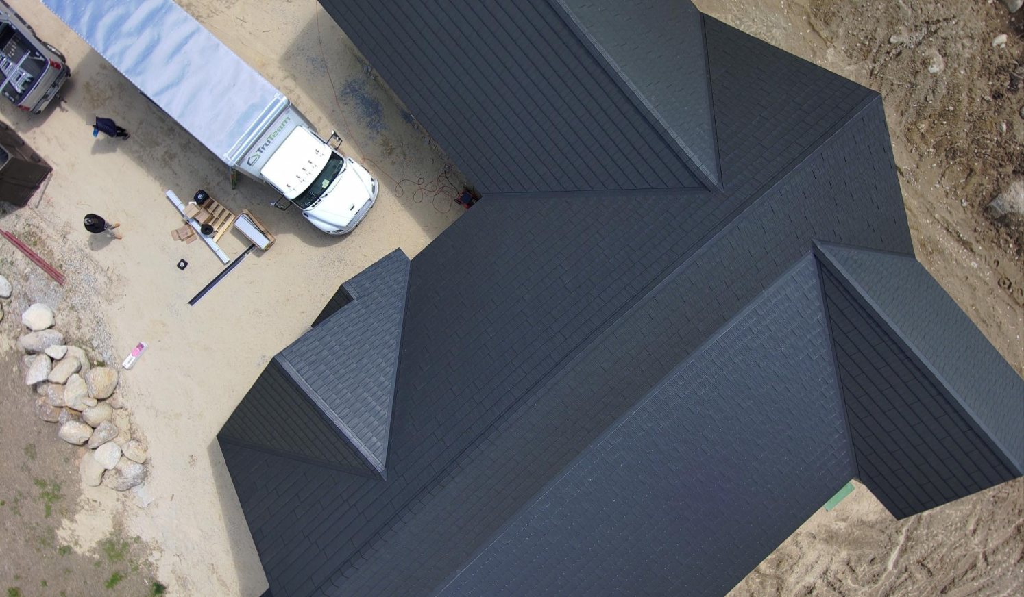 An aerial view of a house under construction with a truck parked in front of it.