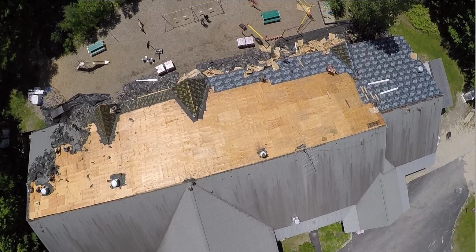 An aerial view of a house with a roof that is being repaired