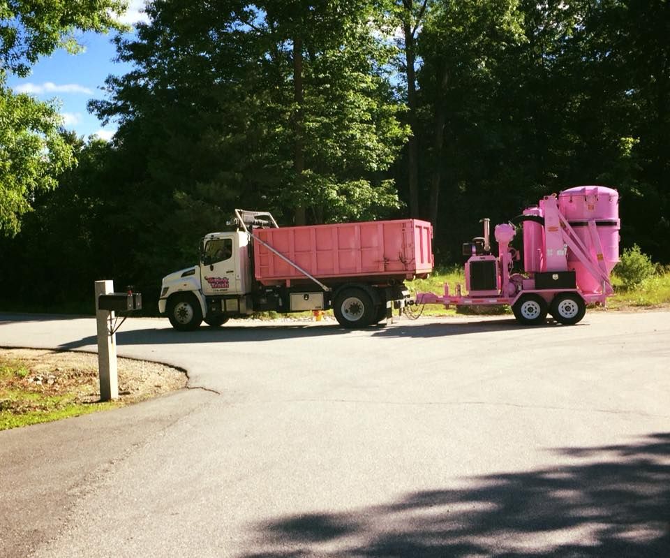 A white truck with a pink trailer attached to it
