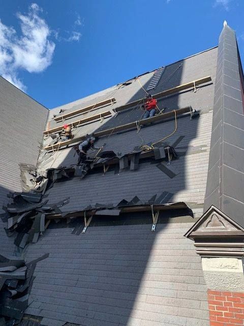 A group of people are working on the roof of a building.