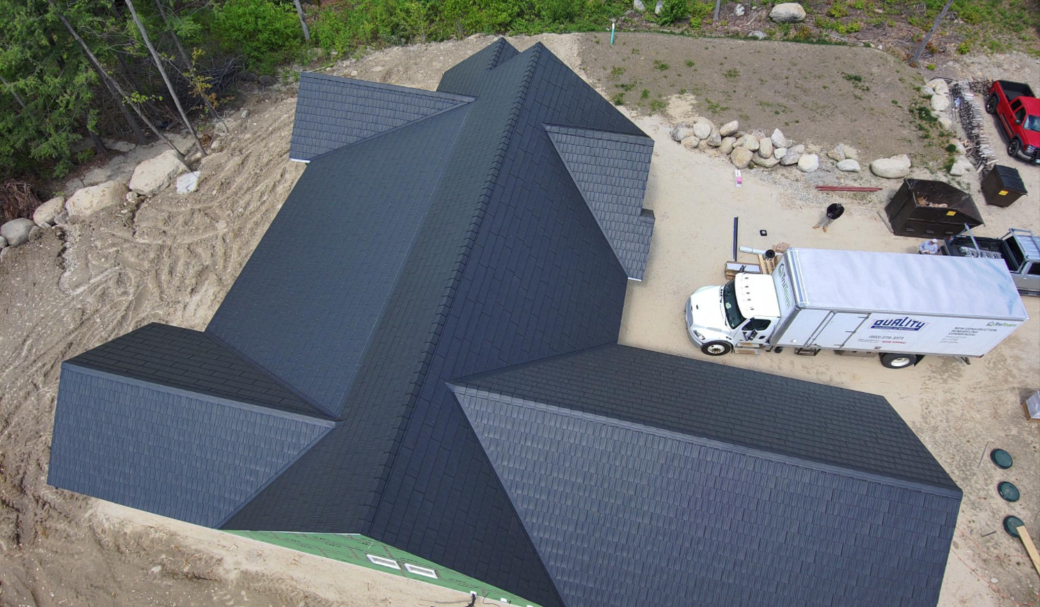 An aerial view of a house under construction with a truck parked in front of it.