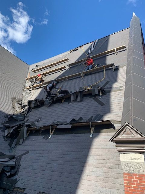 A group of people are working on a roof of a building.