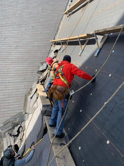 A group of construction workers are working on a roof