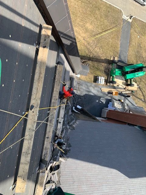 A man is working on the roof of a building