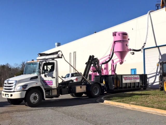 A white truck is parked in front of a white building