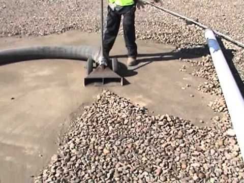 A man is standing on top of a pile of gravel.