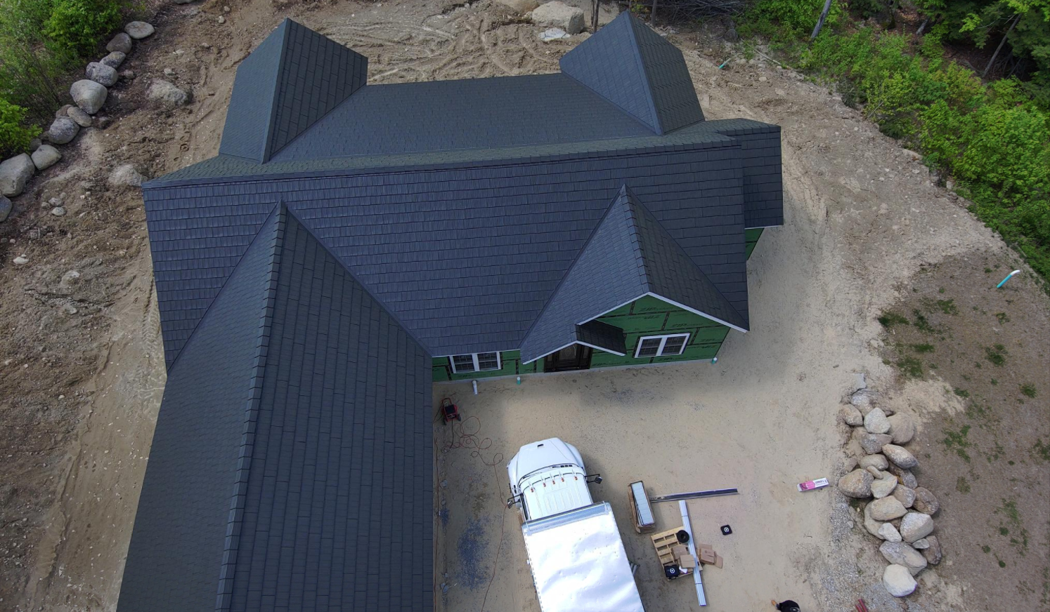 An aerial view of a house under construction with a truck parked in front of it.