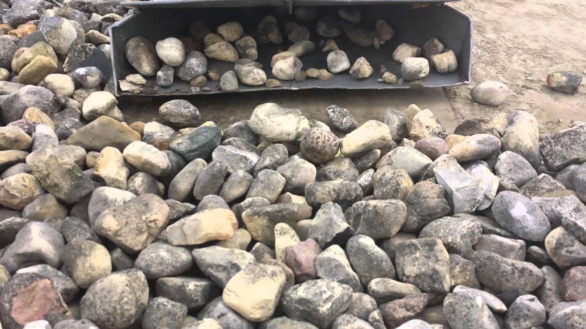 A pile of rocks is sitting on the ground next to a shovel.