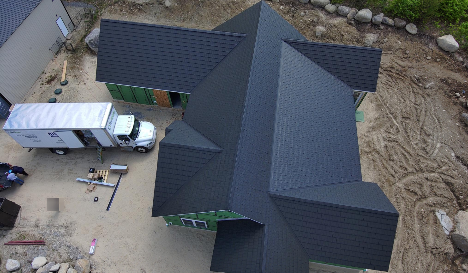 An aerial view of a house under construction with a truck parked in front of it.