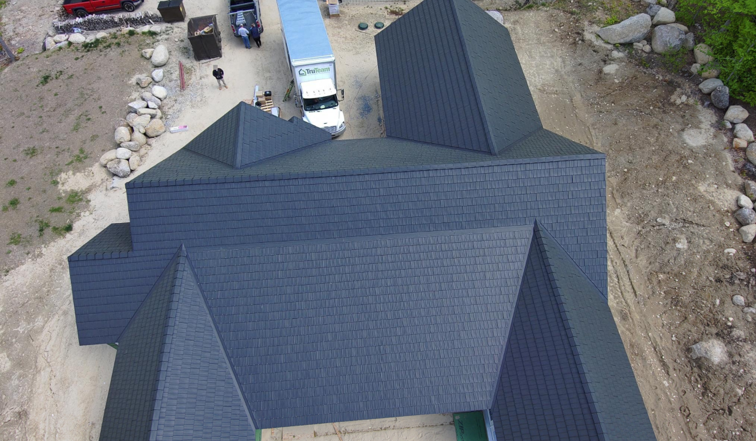 An aerial view of a house under construction with a truck parked in front of it.