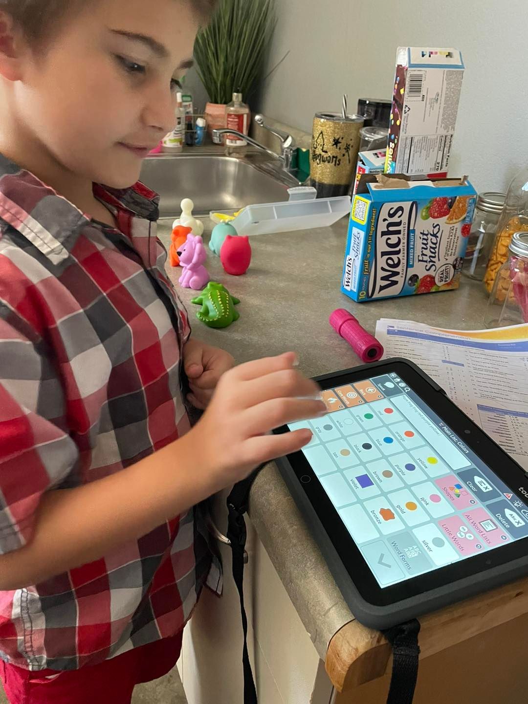 A young boy is playing a game on a tablet.