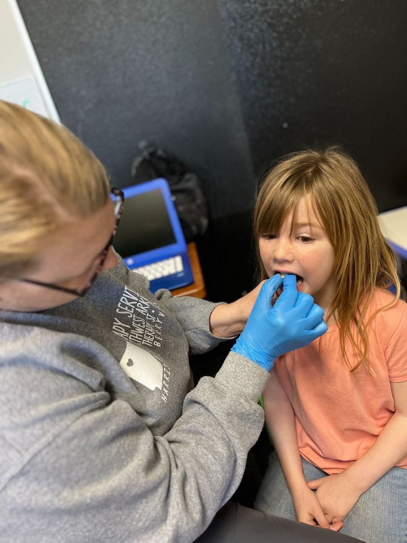A little girl is getting her throat examined by a doctor