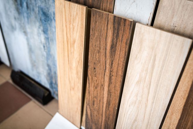 Wood sample boards in light and dark finishes leaning against a wall.