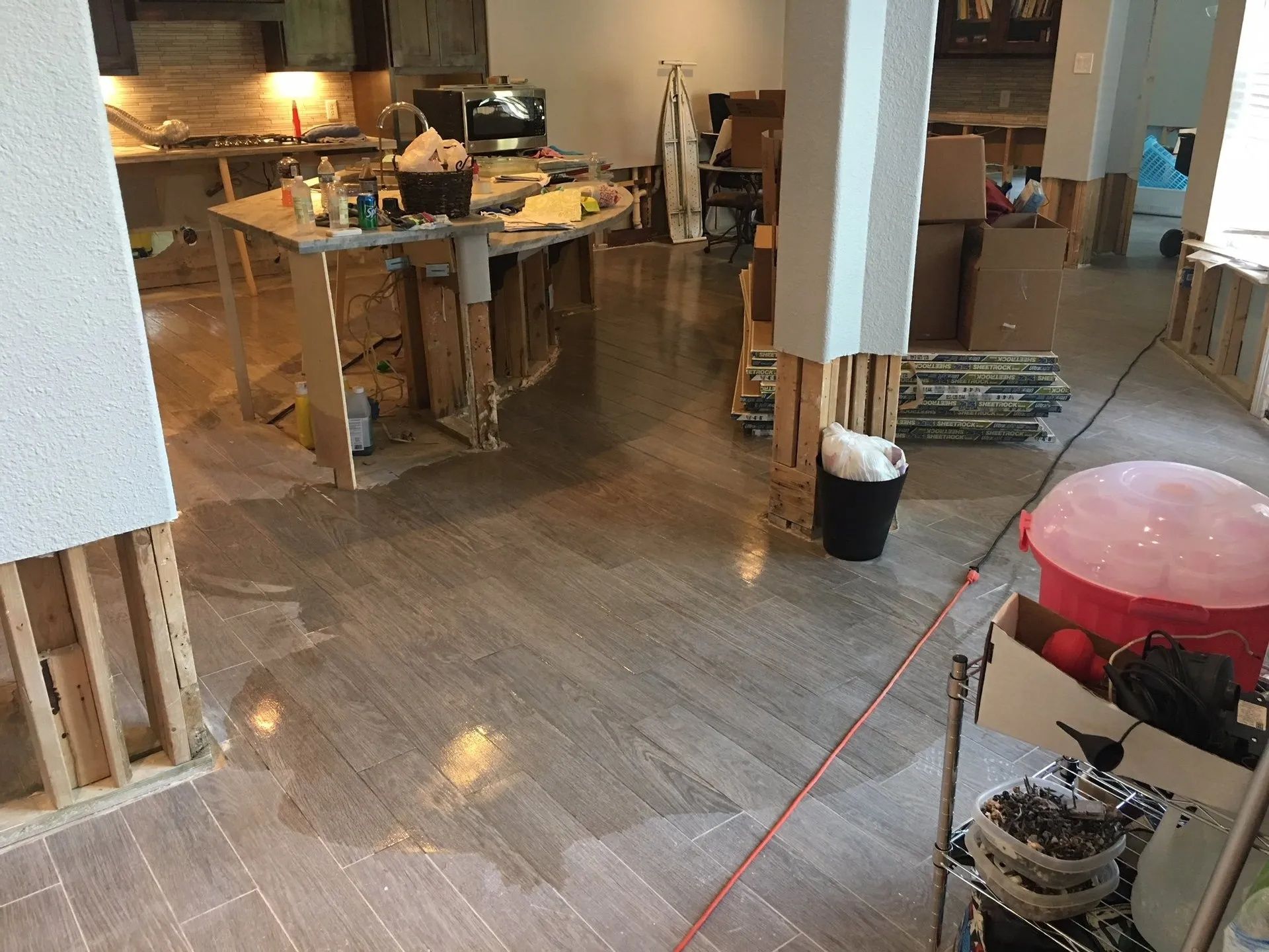 Renovation area with tools, worktables, and exposed flooring in a partially finished room
