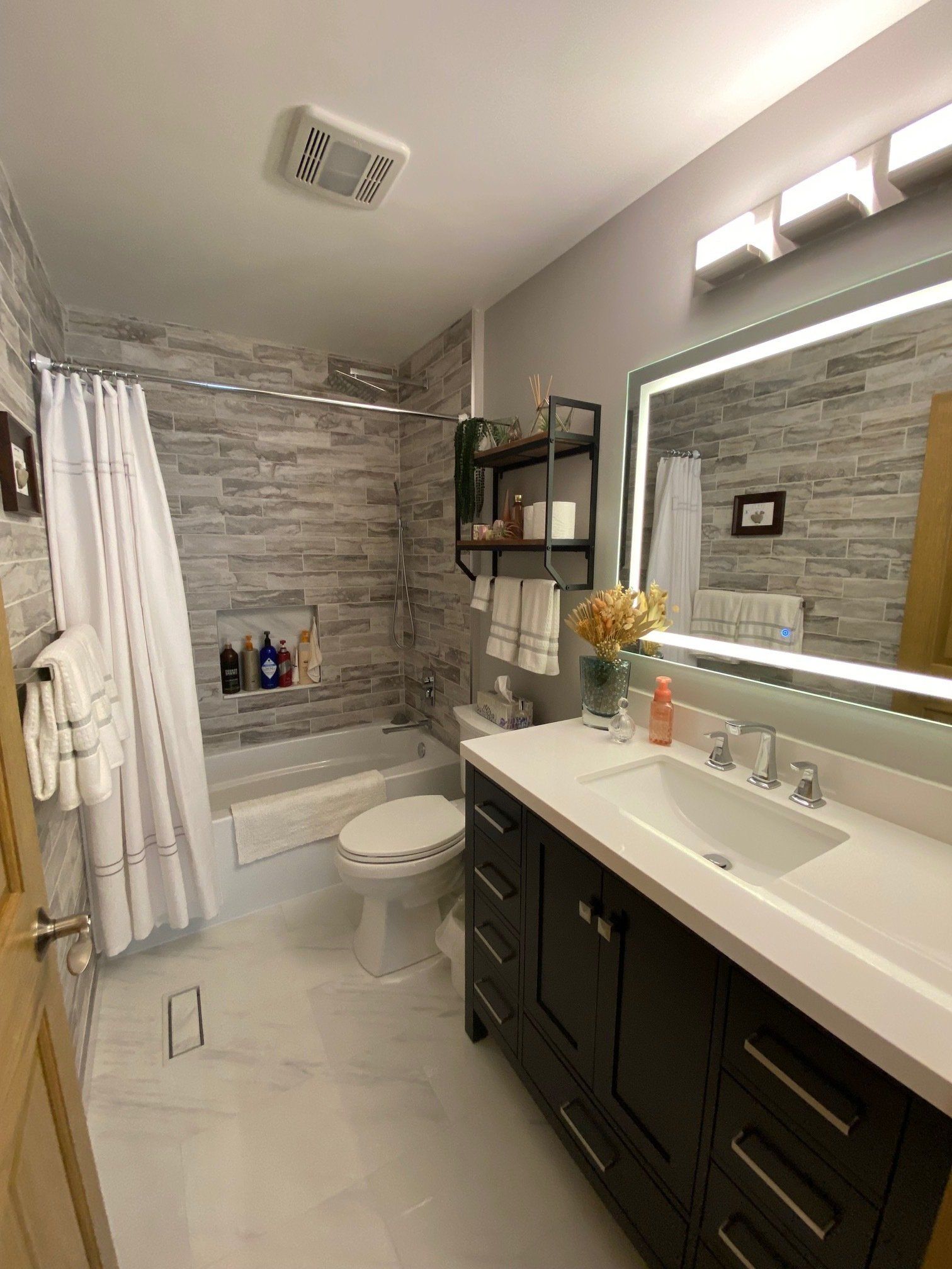 A bathroom with a sink , toilet , bathtub and mirror.