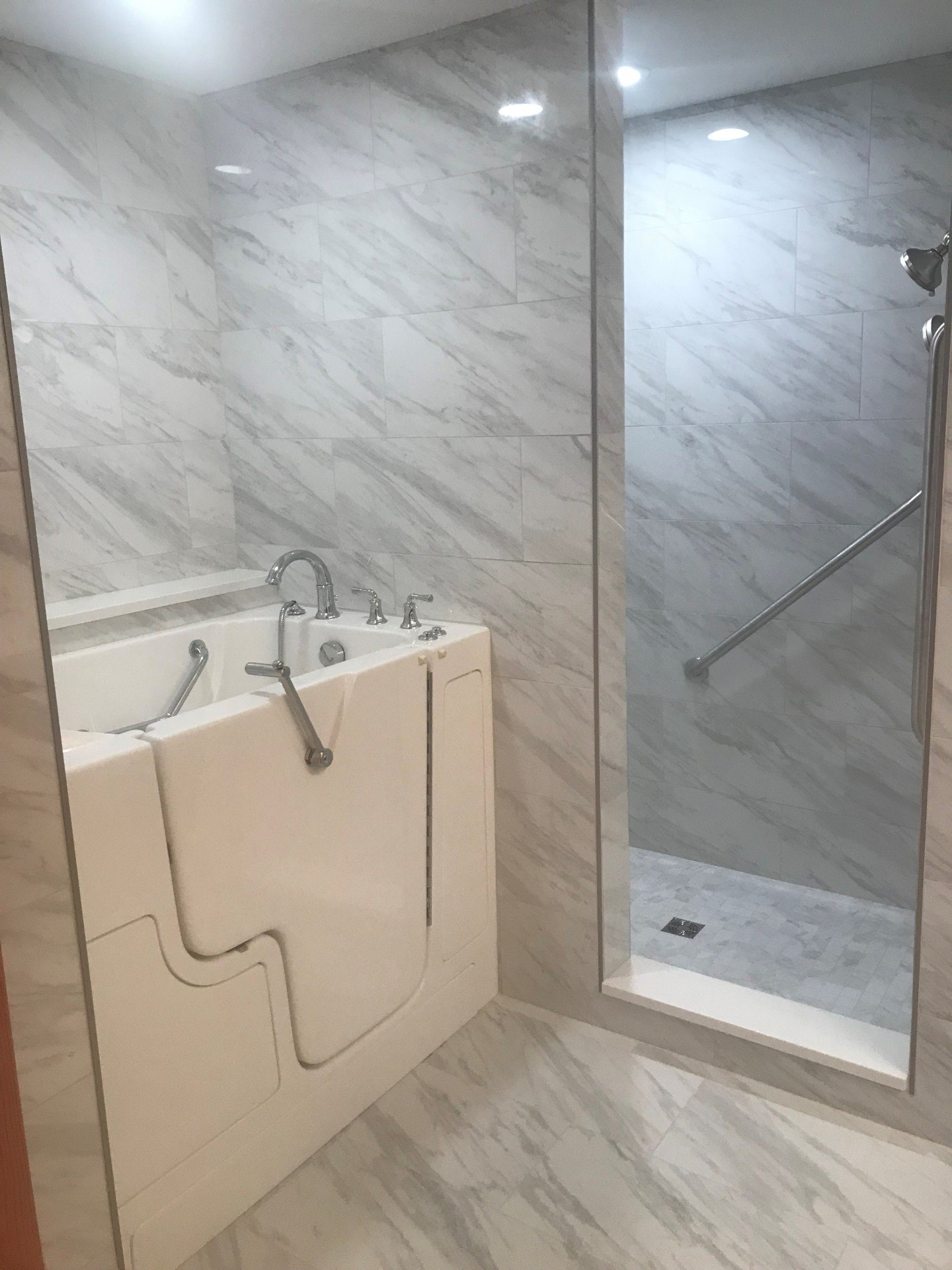 A bathroom with a walk in tub and a walk in shower.