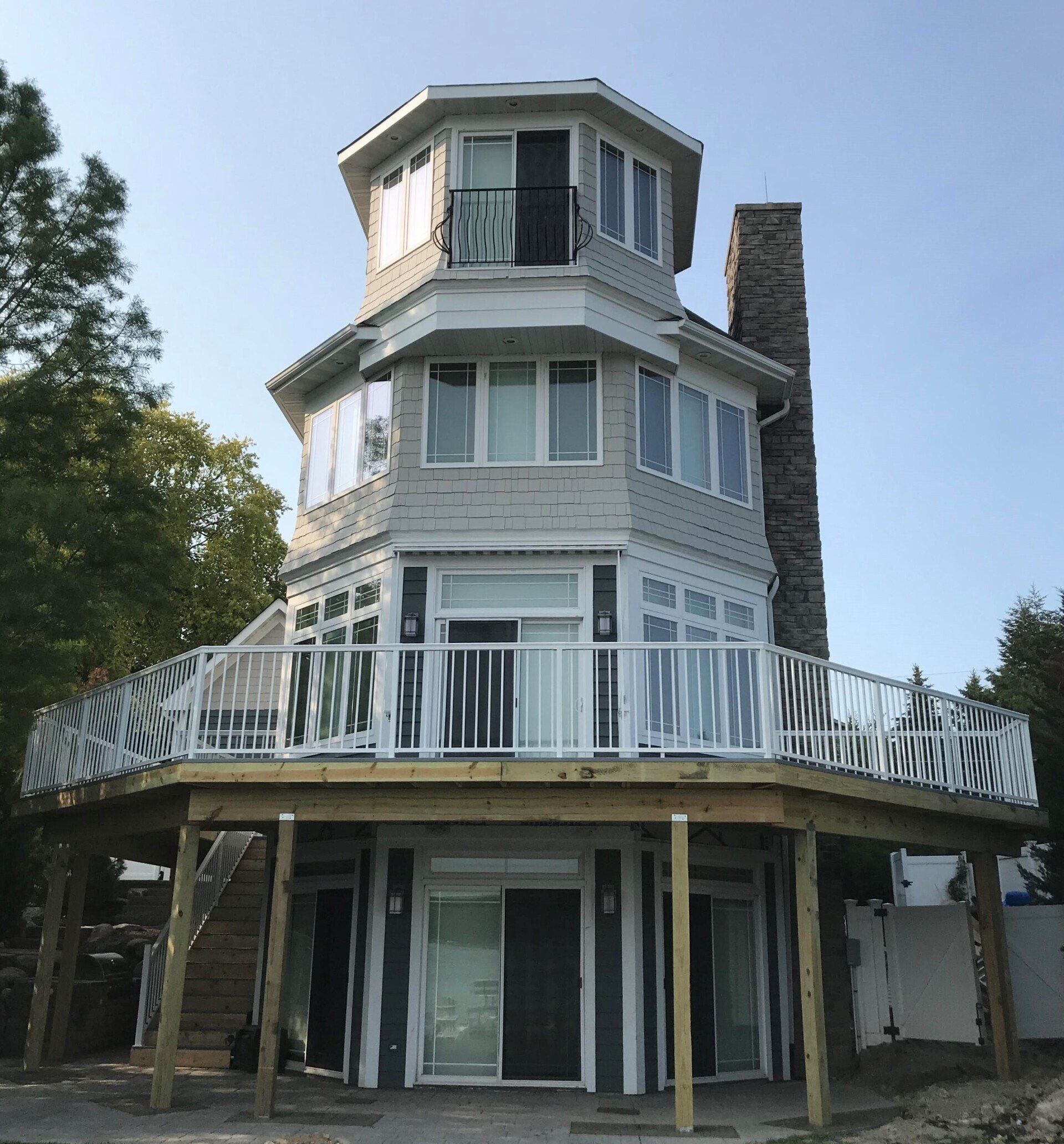 A very tall house with a deck and stairs