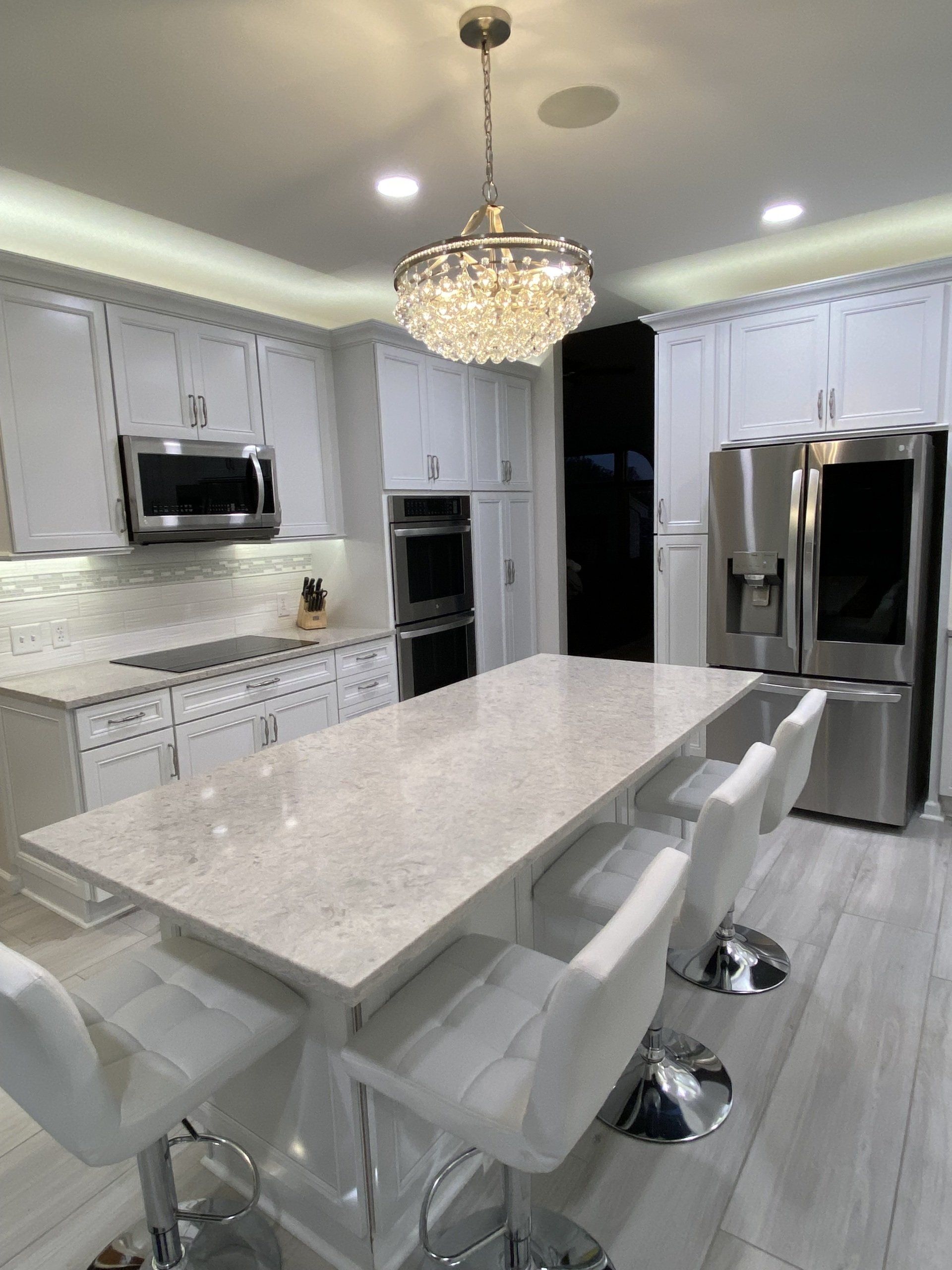 A kitchen with white cabinets and stainless steel appliances