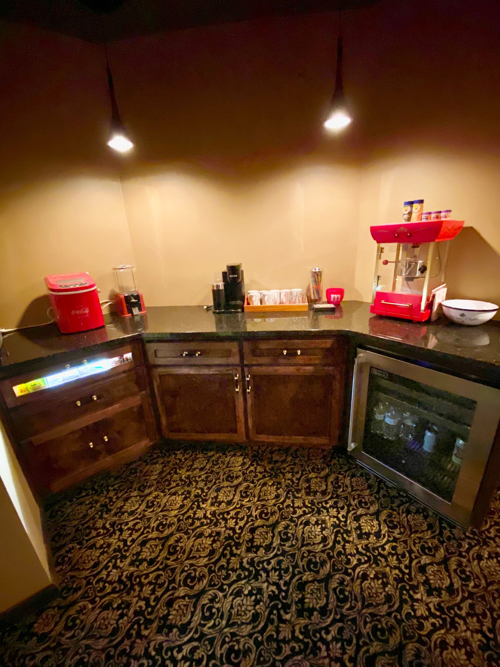 A kitchen with a popcorn machine and a refrigerator.