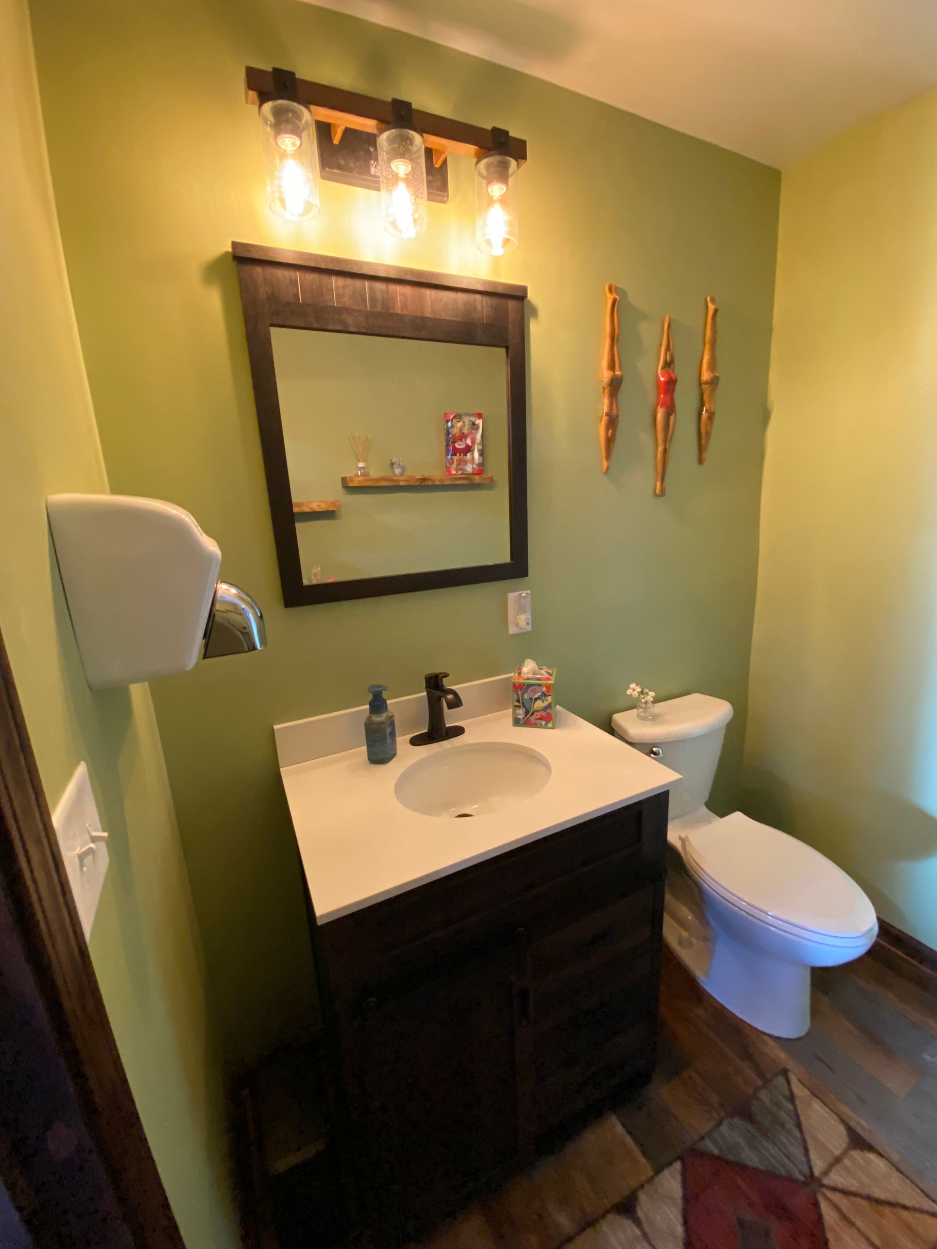 A bathroom with a sink , toilet and mirror
