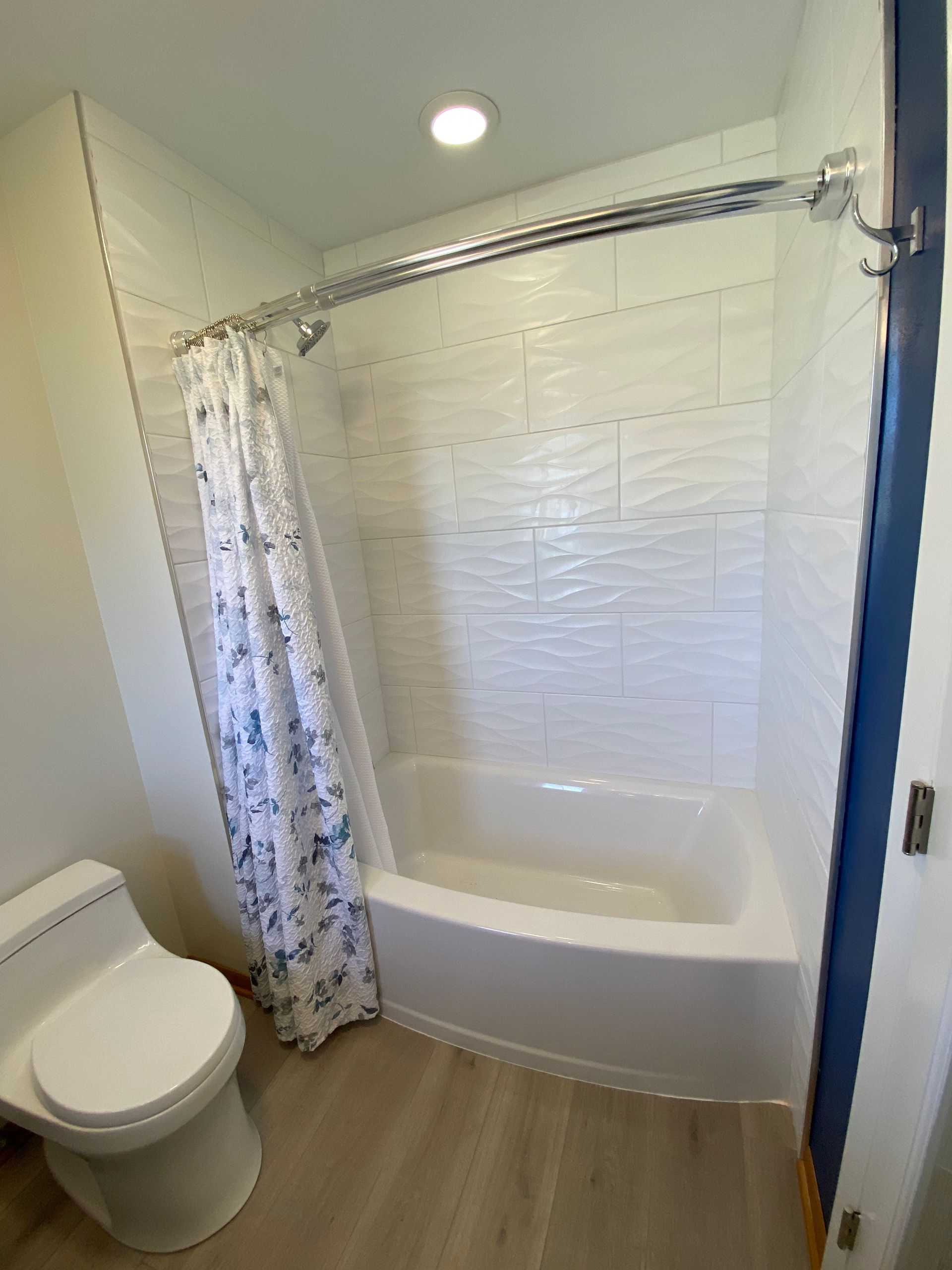 A bathroom with a toilet , tub , shower and shower curtain.