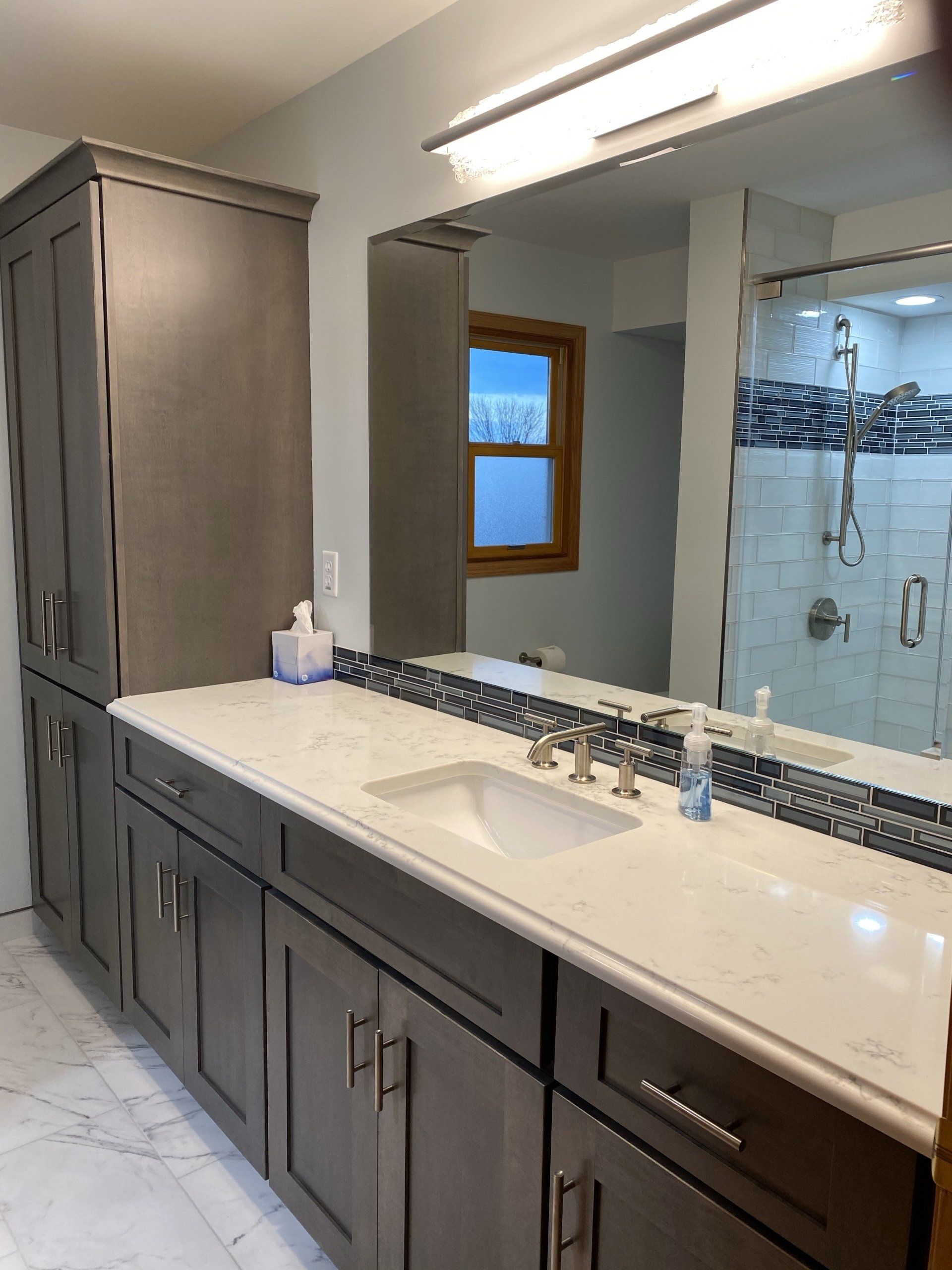 A bathroom with a sink and a large mirror