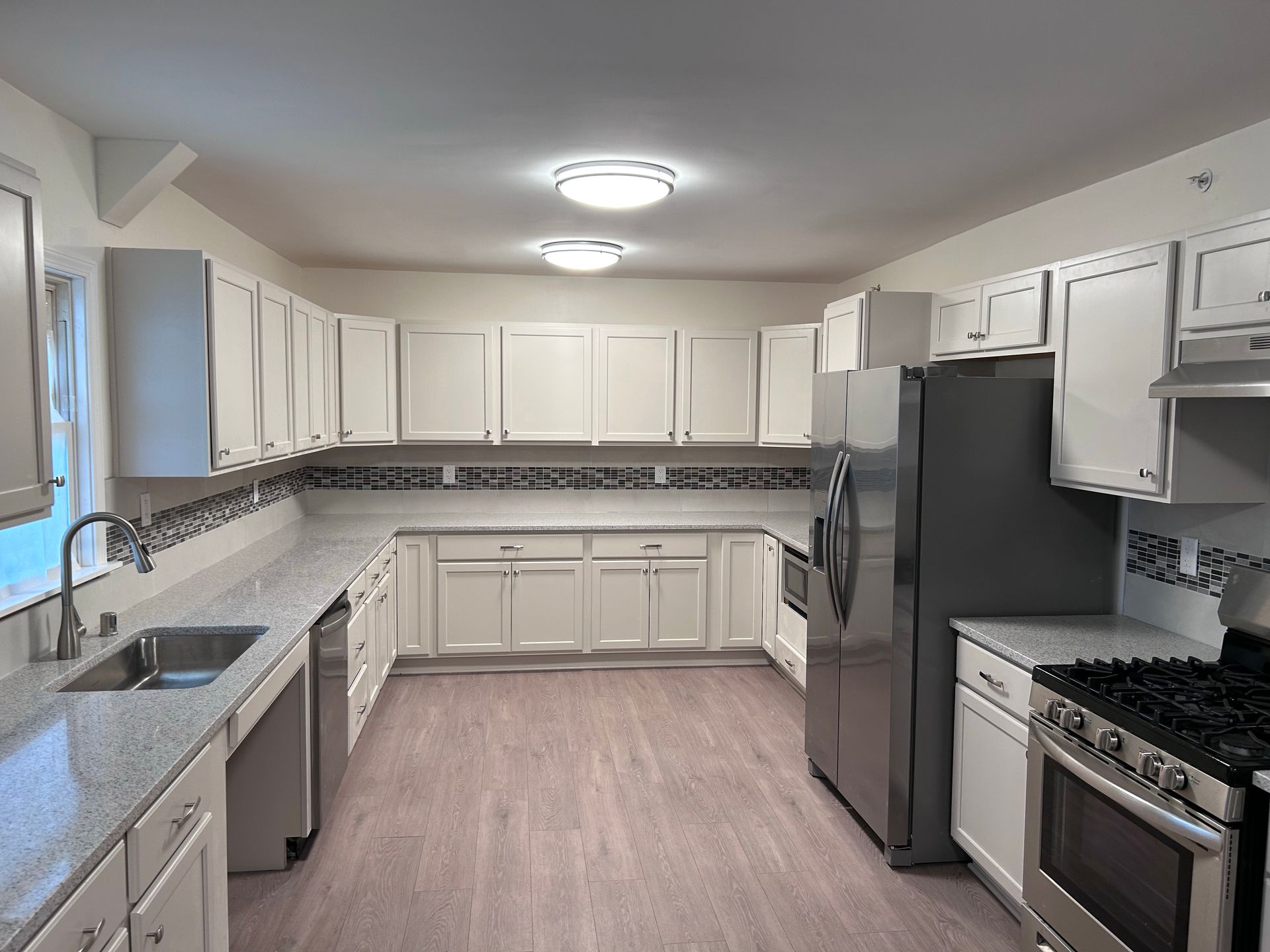 A kitchen with white cabinets and stainless steel appliances
