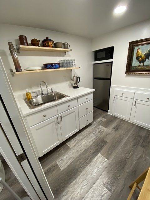 A kitchen with a sink and a picture of a rooster on the wall