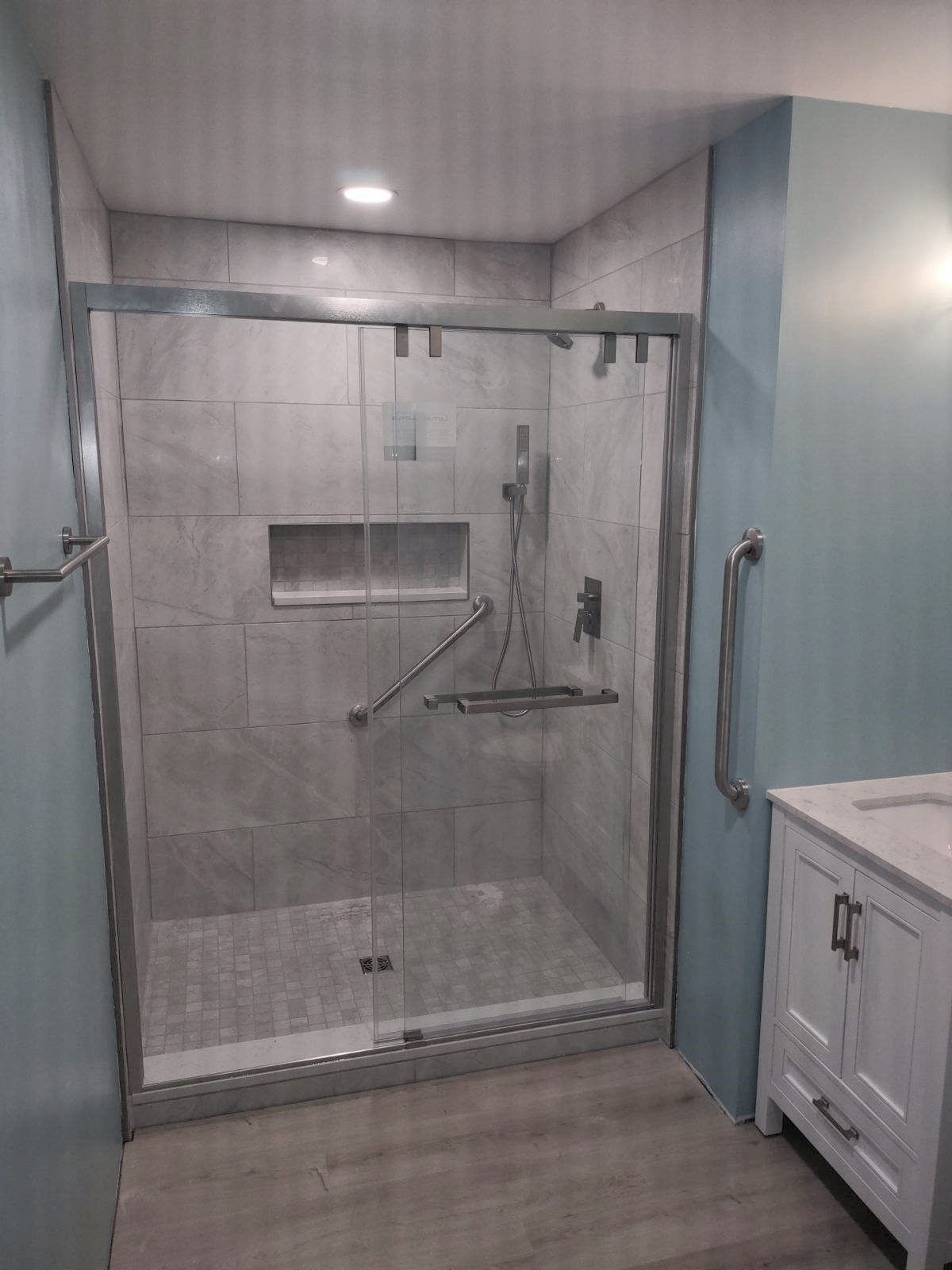A bathroom with a sliding glass shower door and a sink.