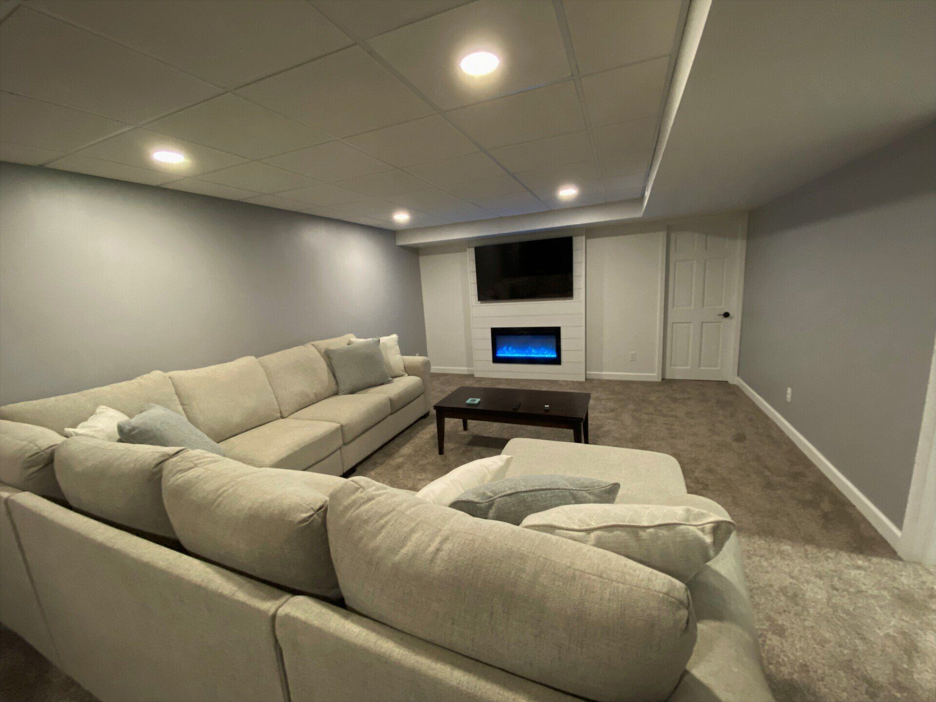 A living room with a couch , coffee table , fireplace and television.