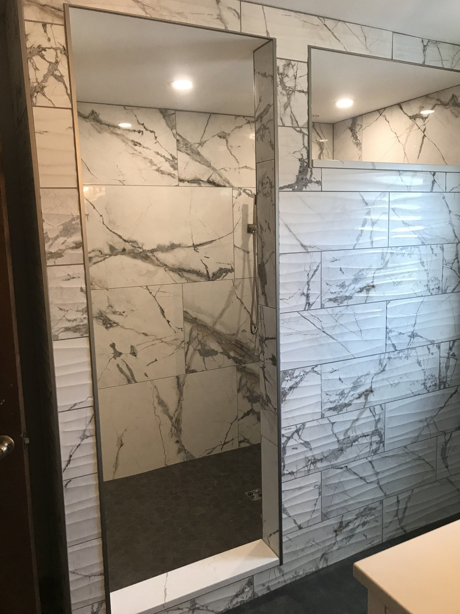 A bathroom with marble tiles and a walk in shower