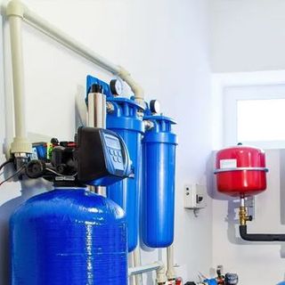 A room with a lot of blue tanks and pipes.