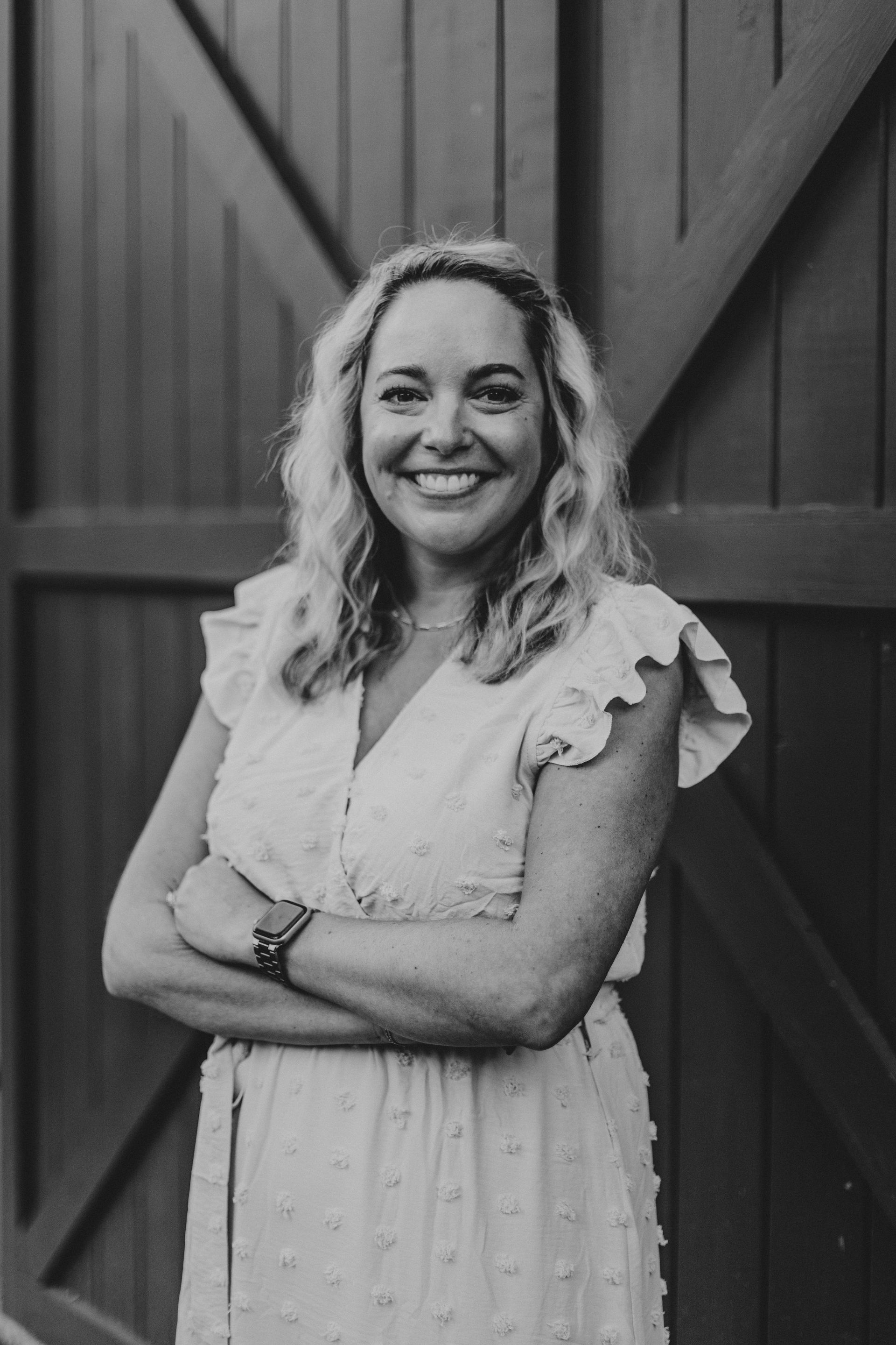 A woman in a black dress is sitting in a chair in a salon.