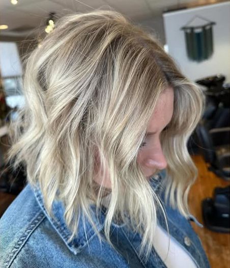 A woman with blonde hair is wearing a denim jacket.