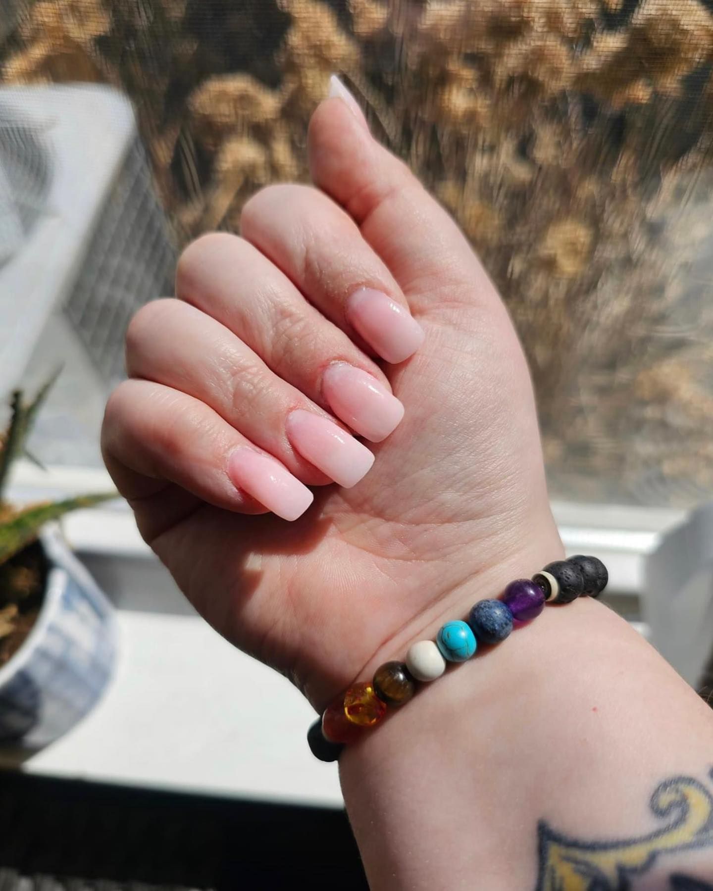 A close up of a woman 's hand with a bracelet on it