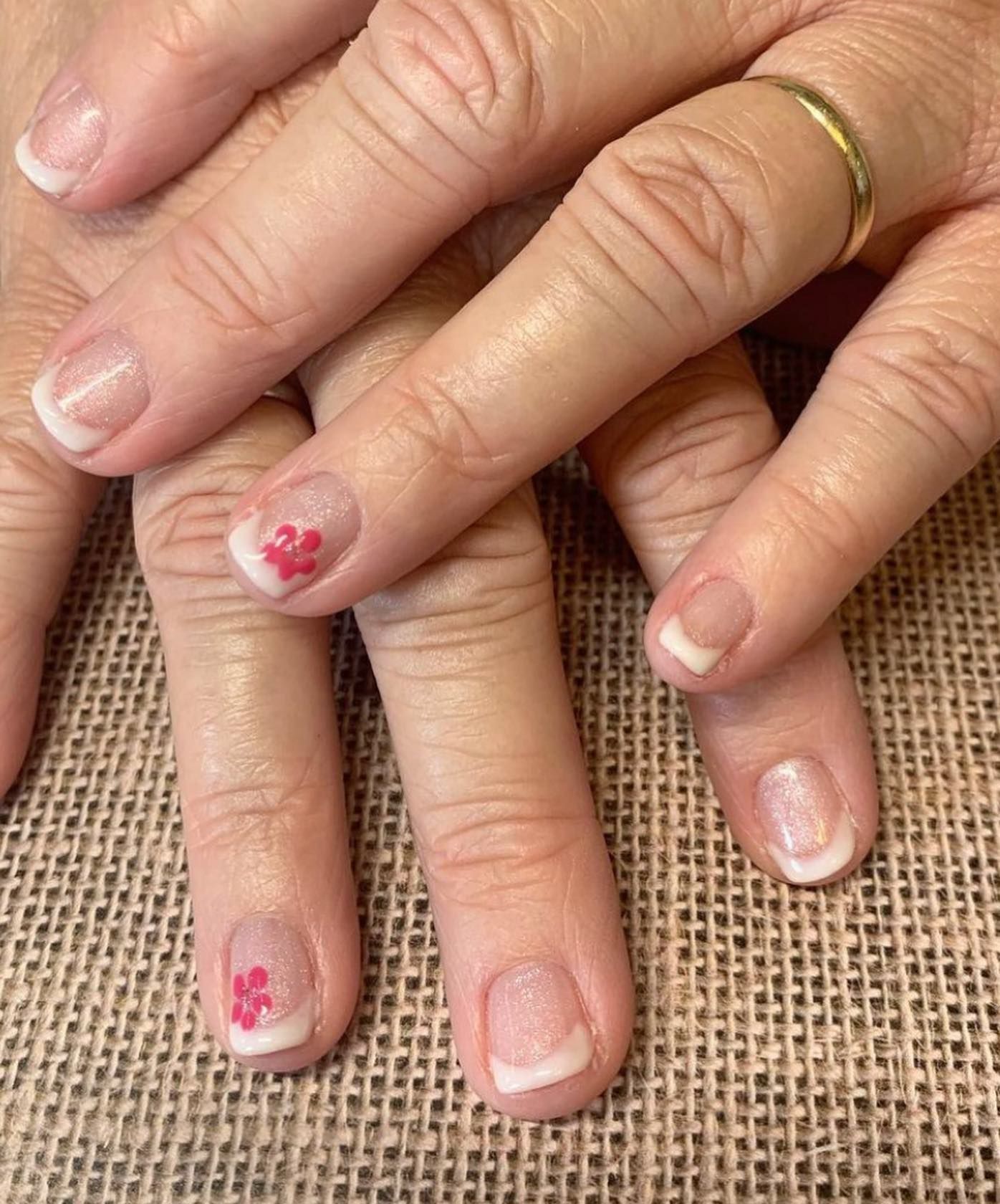 A close up of a woman 's nails with a ring on her finger
