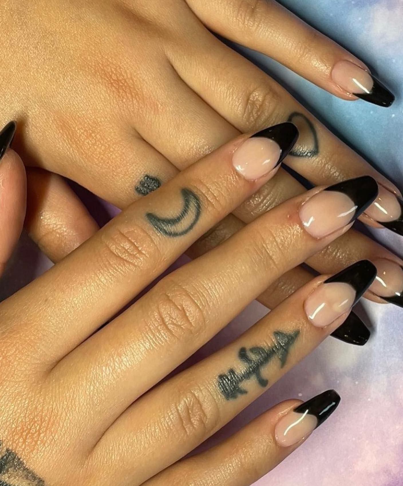 A close up of a woman 's nails with black french manicure