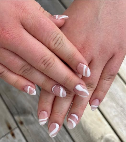 A close up of a woman 's hands with white nails