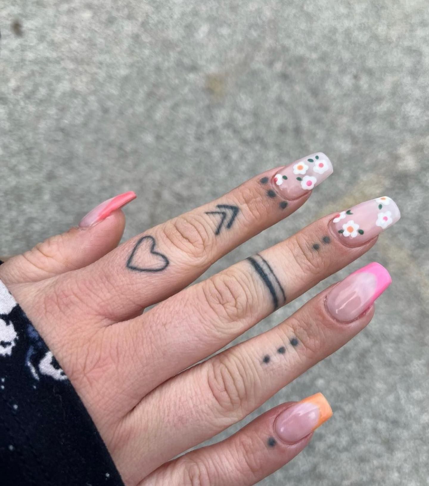 A close up of a person 's hand with a tattoo on their finger.