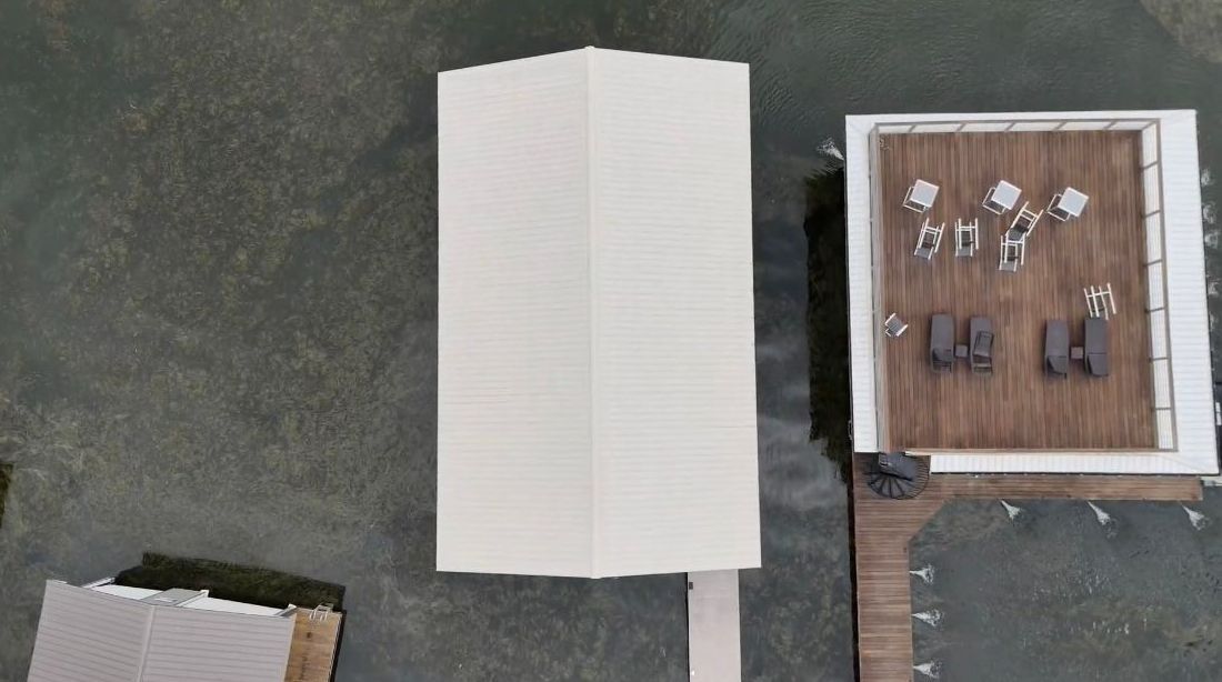 An aerial view of a building with a white roof and a wooden deck.