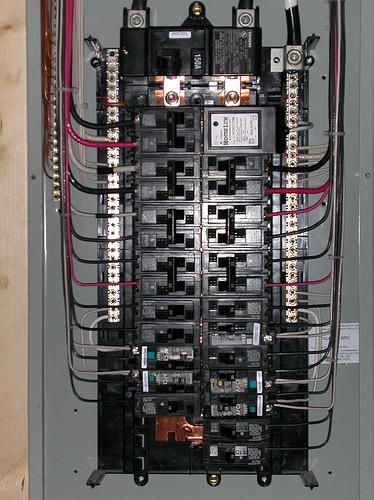 Electrical panel with numerous circuit breakers and wiring.