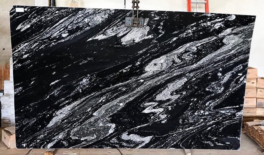 Black and white granite slab with swirled patterns, ideal for countertops or surfaces.