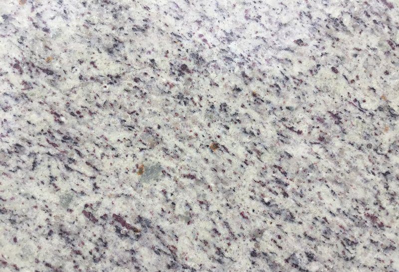 White granite surface with speckled black and purple spots.