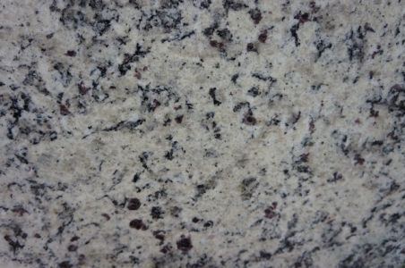 White granite countertop with black and red speckled patterns.