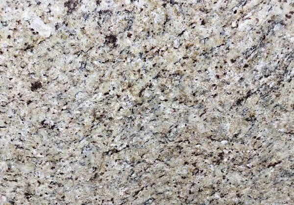 Close-up of light beige granite with dark flecks.