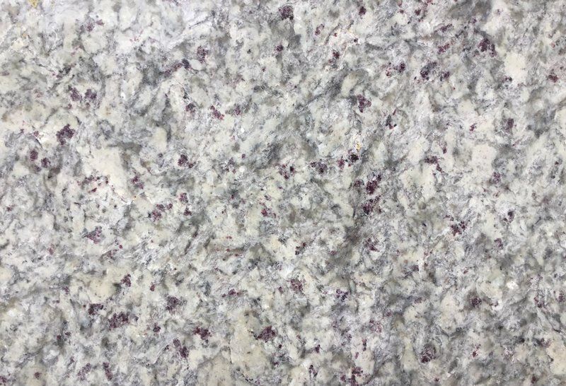 White granite countertop with gray and red-purple flecks.