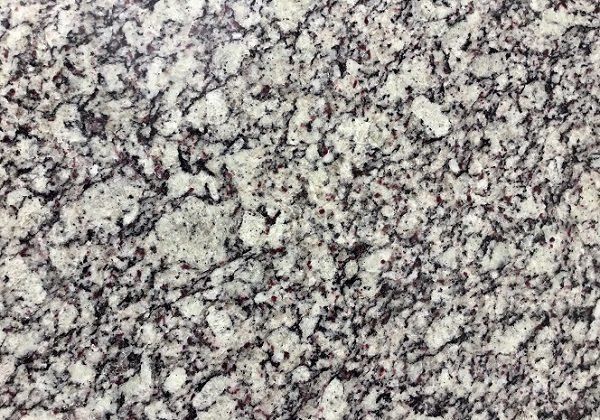 Granite countertop, off-white with gray and black flecks.