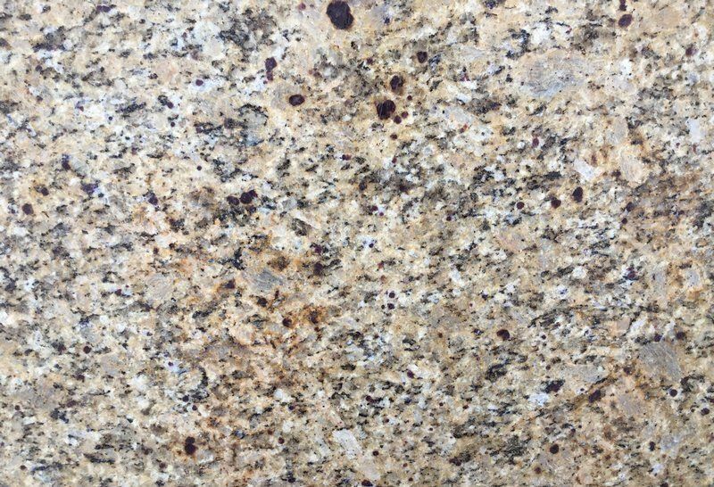 Close-up of granite countertop with beige, black, and brown speckles.