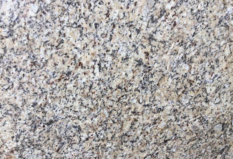 Tan granite countertop with speckled black, gray, and brown markings.